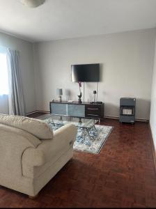 a living room with a couch and a tv at Stay At 7 Self-Catering Apartment in Pietermaritzburg