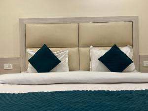 ニューデリーにあるHotel Sapphire International By ASR Hospitalityのベッド1台(上に青い枕2つ付)