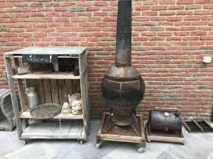 a brick wall with a wood stove next to a building at Studio Au jardin fleuri in Verviers