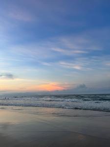a beach with the ocean and a cloudy sky at Hestia HaMy Beach House in Hoi An