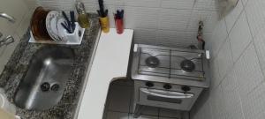 a tiny kitchen with a stove and a sink at Apê da Terezinha in Rio de Janeiro +2 photos
