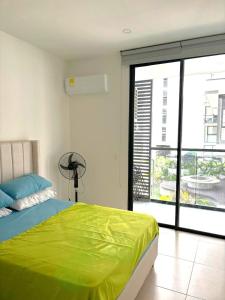 a bedroom with a green bed and a large window at Luxury vacation apartment, sea salt flats in Playa Bello Horizonte