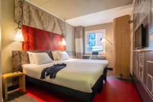 a hotel room with a large bed and a tv at ibis Amsterdam Centre Stopera in Amsterdam +69 photos