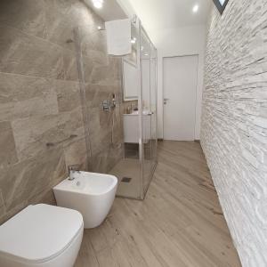 a bathroom with a toilet and a shower and a sink at Villa Mare Luna in Balestrate