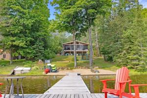 a house on the lake with a dock and chairs at Muskoka Gem 8ppfireplacescanoekayaks in Bracebridge