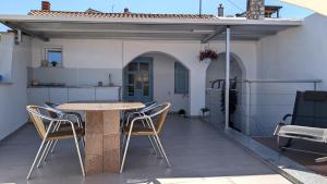 a patio with a table and chairs on a house at Ferienwohnung Azur in Selce +7 photos