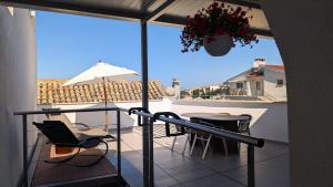 a balcony with chairs and a table and an umbrella at Ferienwohnung Azur in Selce