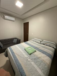 a bedroom with a bed with a green towel on it at Apartamento Frente à Praia da Graciosa in Palmas