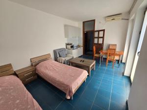 a bedroom with a bed and a table and a kitchen at Villa Relax Apartments in Budva