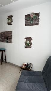 a living room with a couch and flowers on the wall at Mírame Canarias in Vecindario
