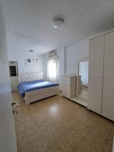 a bedroom with a bed and a dresser and a mirror at דירה בעמק in Bet Sheʼan
