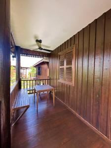 a wooden room with a bench and a table at Roya Khmer Homestay in Siem Reap