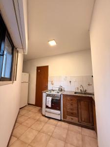 a kitchen with a stove and a sink at Dto centro RG in Bahía Blanca +5 photos