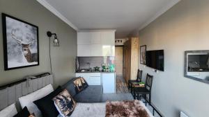 un soggiorno con divano e cucina di Ski In Ski Out Tiamo apartment 402 at Gudauri Loft Hotel a Gudauri