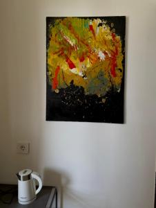 una pintura colgada en una pared junto a una mesa en mood hotel kazbegi garden, en Kazbegi