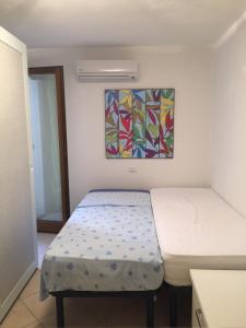 a bedroom with two beds and a painting on the wall at VILLA VISTA MARE INFINITY POOL in Marinella