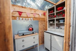 a kitchen with white cabinets and a tea kettle at Cefn Crib Safari Tent in Machynlleth