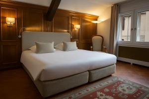 a bedroom with a large white bed and a window at Georges Blanc Parc & Spa - Relais & Chateaux in Vonnas