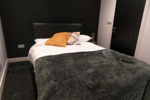 a bed with two pillows and a blanket on it at Credit Corner Studio in Brierley Hill