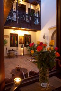 un jarrón con flores en una mesa en una habitación en Riad Aubrac en Marrakech