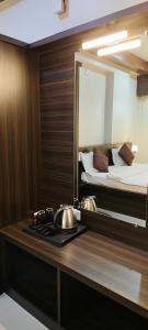 a kitchen with a counter with a mirror and a bed at Hotel SAVI SAGAR in Kundapur
