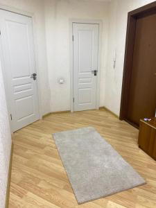 an empty room with two white doors and a rug at 2 комнатная квартира золотой квадрат ЖК Москва in Astana +1 photo