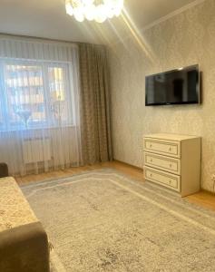 a living room with a television and a dresser at 2 комнатная квартира золотой квадрат ЖК Москва in Astana