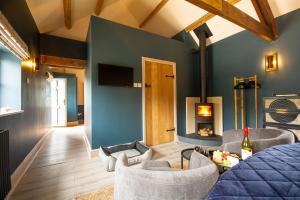 a room with a bed and chairs and a fireplace at Bolesworth Bothy in Tattenhall