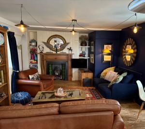 ein Wohnzimmer mit Couch und Kamin in der Unterkunft The beach cottage in Folkestone