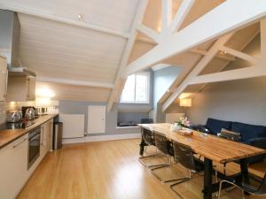 eine Küche und ein Esszimmer mit einem Holztisch in der Unterkunft 2 The Old School House in Dartmouth