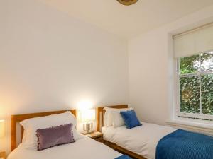 zwei Betten in einem Zimmer mit Fenster in der Unterkunft 2 The Old School House in Dartmouth