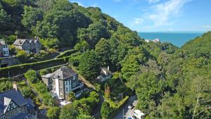 an aerial view of a mansion in the hills with the ocean at The Cottage at Woodlands in Lynton
