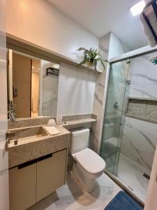 ein Badezimmer mit Toilette und Glasdusche in der Unterkunft Mirante Porto Galinhas beira-mar in Porto De Galinhas