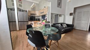 sala de estar con mesa de cristal y sillas negras en Centre Carré d'or 3 chambres, en Cannes