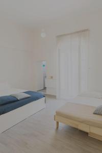 a white bedroom with a bed and a table at AGAR Rooms in Matera