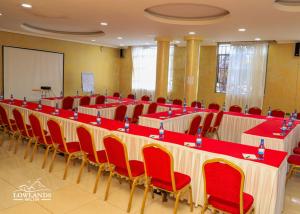 a conference room with a long table and red chairs at Lowlands Hotel & Spa in Chuka +44 photos