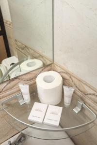 a glass table with a toilet and a mirror at Lowlands Hotel & Spa in Chuka