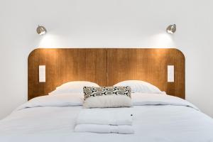 a large white bed with a wooden headboard at La Maison Générale in Besançon +64 photos