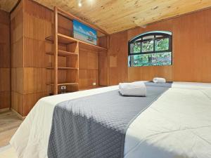 a bedroom with a large bed in a room at 1 suíte Jacuzzi Lareira Churrasqueira in Campos do Jordão