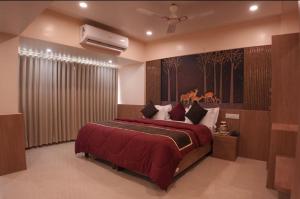 a bedroom with a large bed with a red blanket at The Moris palace hotel in Rajkot +10 photos