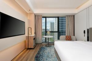 a hotel room with a bed and a flat screen tv at Holiday Inn Express Taizhou Jiaojiang in Taizhou +45 photos
