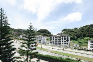 een stadsstraat met gebouwen en een dennenboom bij Cameron Centrum CozyNest with Kids Play Area Clover Home A-1-15A in Brinchang