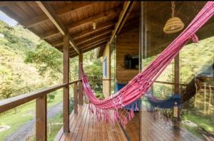 a hammock on a porch of a house at Cabanas do Rio in Alfredo Wagner