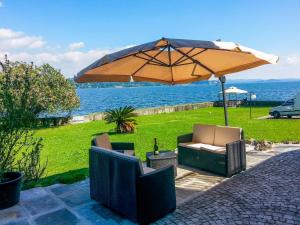 La Villa di Elena في فيربانيا: مظلة وكرسيين تحت طاولة مع المحيط