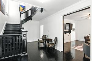 a living room with a staircase and a table and chairs at Historic Elegance in the Heart of Elizabeth City home in Elizabeth City