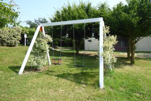 a swing set in a yard with flowers at Silea Apartments, Pool, Garden, Treviso in Silea