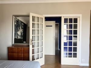 1 dormitorio con puerta blanca y vestidor en l OSTAL BLAU, en Rodez 3 fotos más
