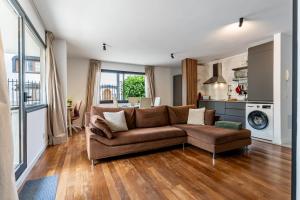 un salon avec un canapé marron et une cuisine dans l'établissement Centric and bright apartment - Puerto de La Cruz, à Puerto de la Cruz