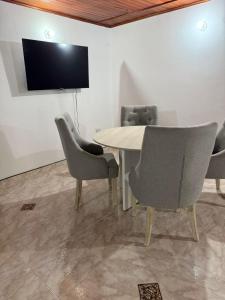 a dining room with a table and chairs and a tv at Apartamento Comodo En Riascos in Santa Marta