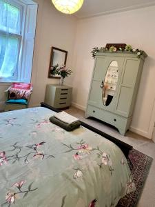 een slaapkamer met een bed en een wasmachine bij Dairsie Sea View in Rothesay +18 foto's